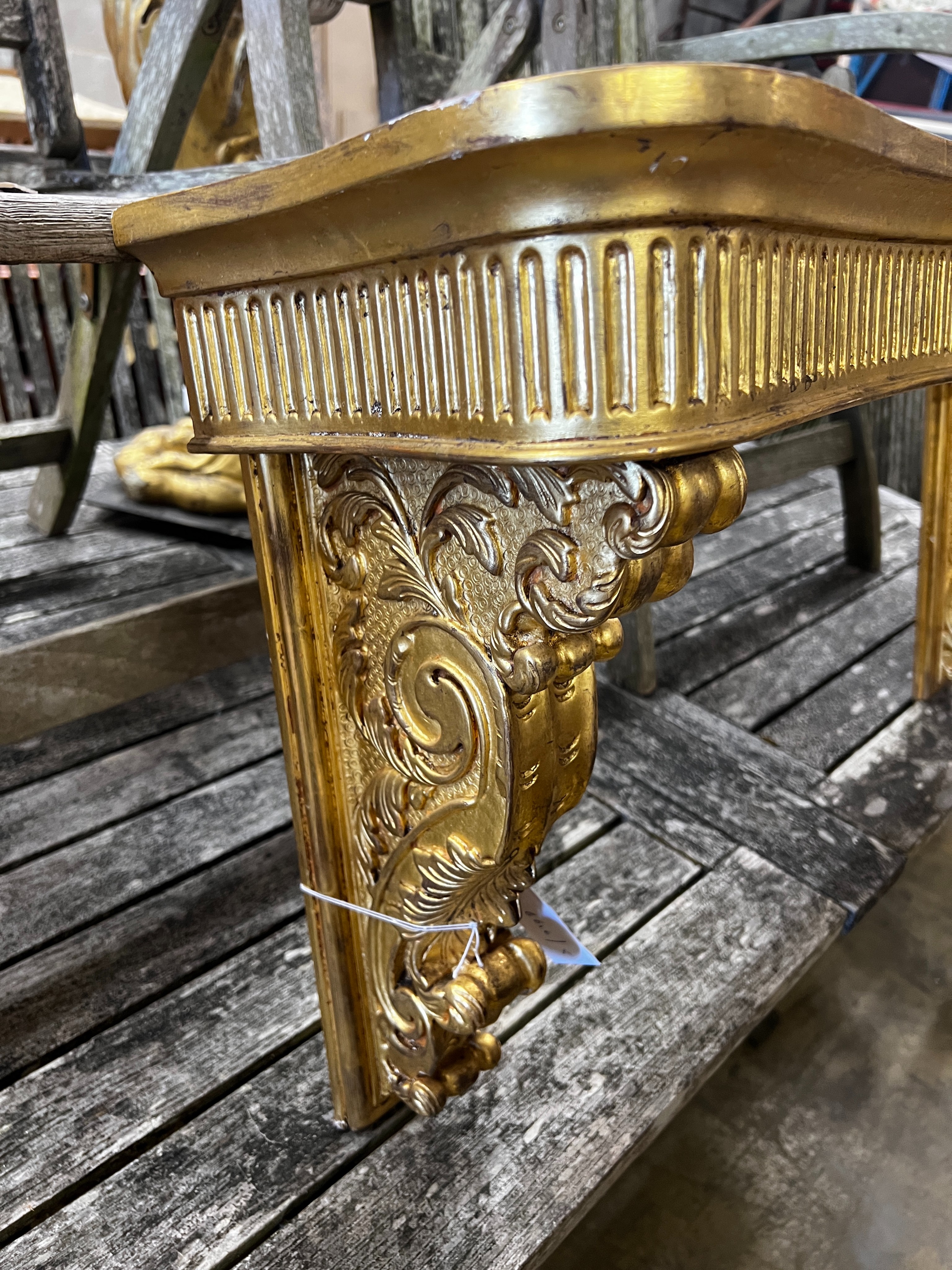 An 18th century style carved giltwood and composition console table (lacks marble top), width 90cm, height 46cm